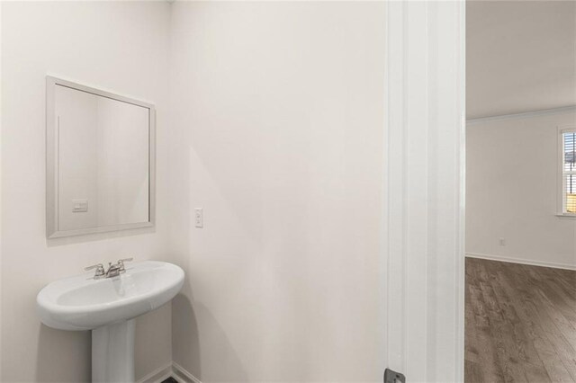 unfurnished living room with sink, ceiling fan, crown molding, and dark wood-type flooring