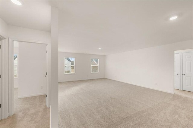 carpeted empty room with a raised ceiling and ceiling fan