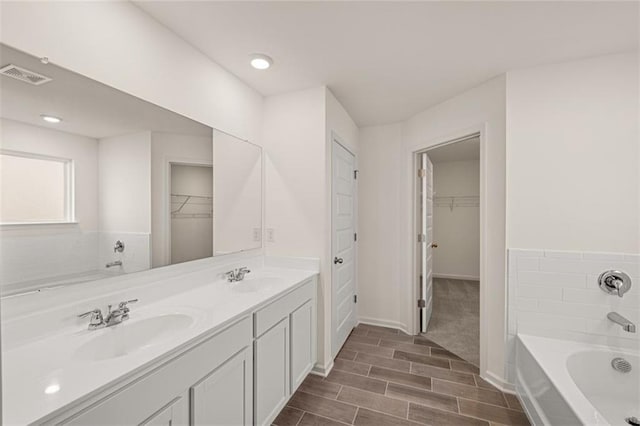 bathroom featuring a washtub and vanity