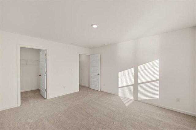 spacious closet featuring light colored carpet