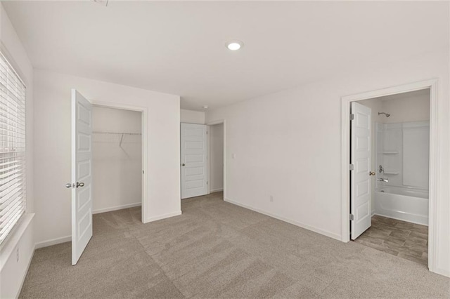 unfurnished bedroom with ensuite bathroom and light colored carpet