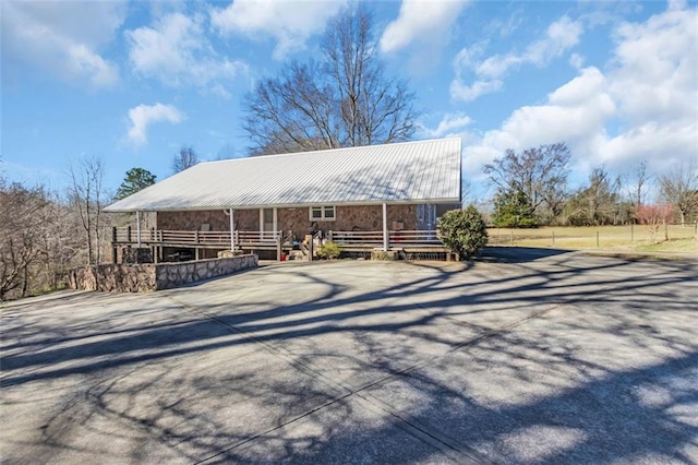 view of front of property with concrete driveway and metal roof