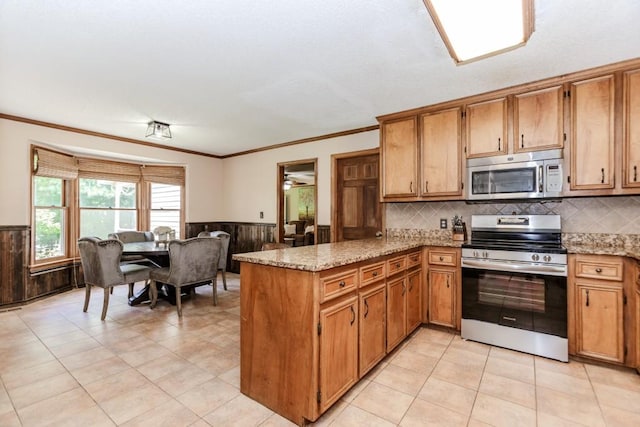 750 Jett Roberts Rd, Jefferson, GA 30549 - kitchen featuring stainless steel appliances, a peninsula, wainscoting, ornamental molding, and light stone countertops
