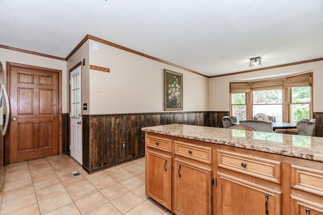 750 Jett Roberts Rd, Jefferson, GA 30549 - kitchen with wainscoting, ornamental molding, wood walls, light stone counters, and light tile patterned flooring