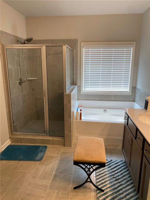 115 Harmony Farms Dr, Eatonton, GA 31024 - bathroom with a bath, a shower stall, vanity, and tile patterned floors