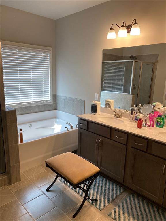 115 Harmony Farms Dr, Eatonton, GA 31024 - full bath with tile patterned flooring, a bath, a stall shower, and double vanity