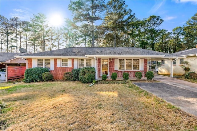 ranch-style house with driveway, a front yard, a carport, and brick siding