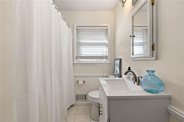 bathroom with visible vents, toilet, a textured ceiling, vanity, and tile patterned flooring