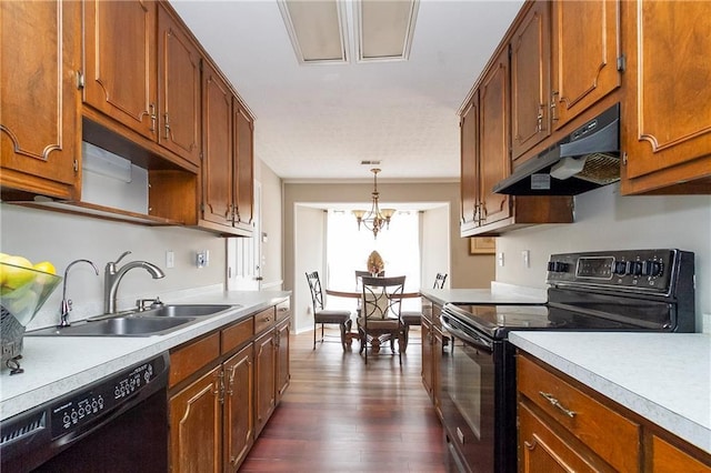 kitchen featuring brown cabinets, black appliances, under cabinet range hood, a sink, and light countertops