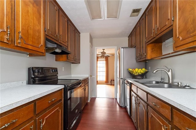 kitchen with visible vents, black electric range oven, under cabinet range hood, a sink, and light countertops