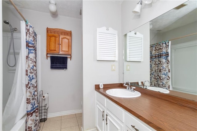 full bathroom featuring visible vents, baseboards, vanity, tile patterned floors, and a textured ceiling