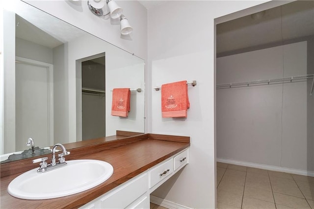 bathroom with vanity, tile patterned floors, and a spacious closet