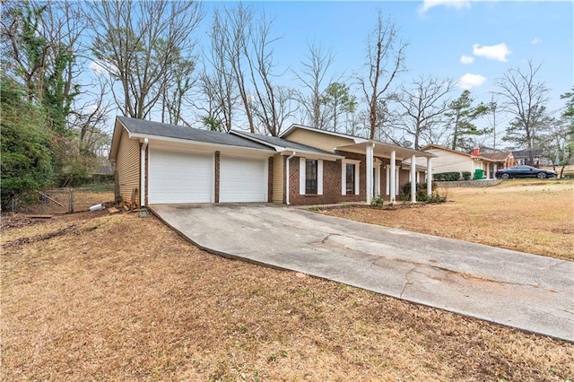 ranch-style home with brick siding, driveway, an attached garage, and a front lawn