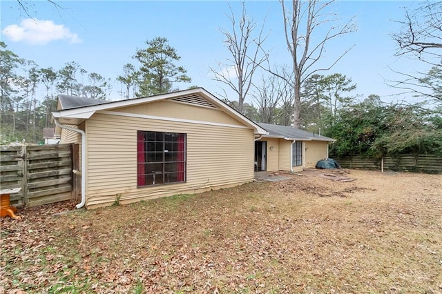 rear view of house featuring fence