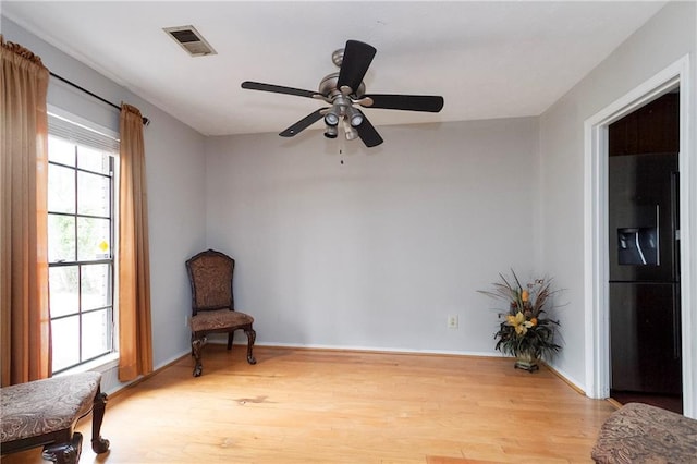 sitting room with visible vents, baseboards, and light wood-style floors