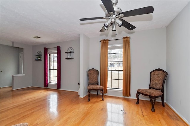 living area with visible vents, baseboards, and light wood-style floors