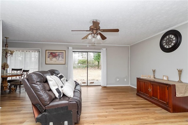 living area with light wood-type flooring, a textured ceiling, and ornamental molding