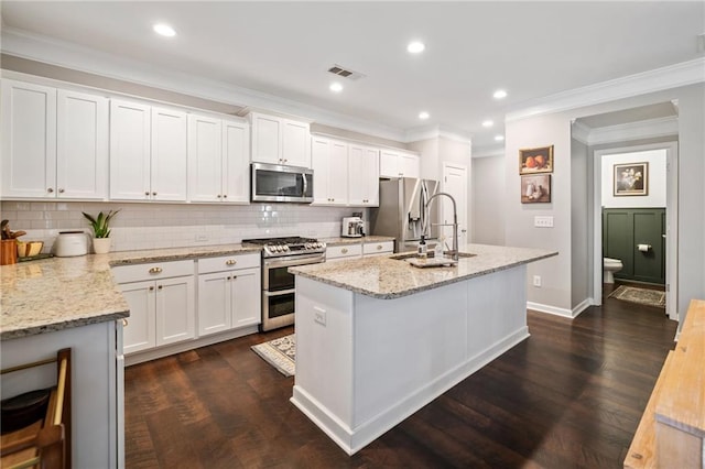 kitchen featuring sink, white cabinetry, stainless steel appliances, light stone countertops, and a center island with sink