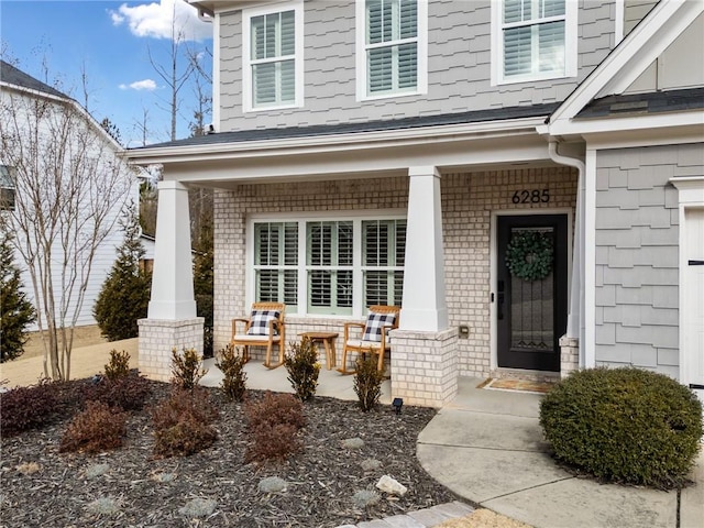 view of exterior entry featuring covered porch