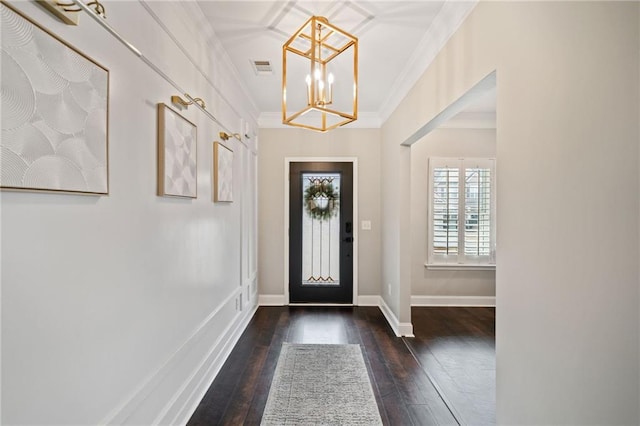 entryway with ornamental molding, dark hardwood / wood-style floors, and a chandelier