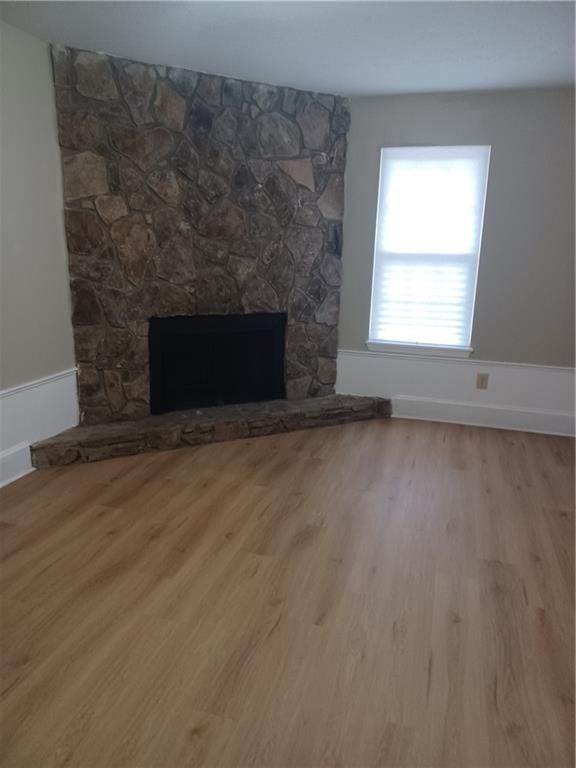 interior details featuring a stone fireplace and hardwood / wood-style floors