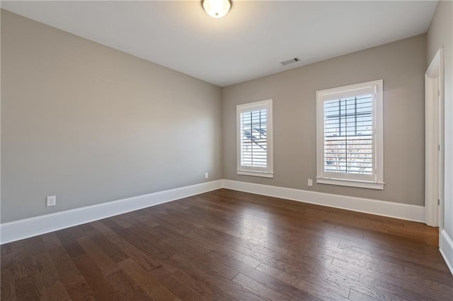 empty room with dark hardwood / wood-style flooring