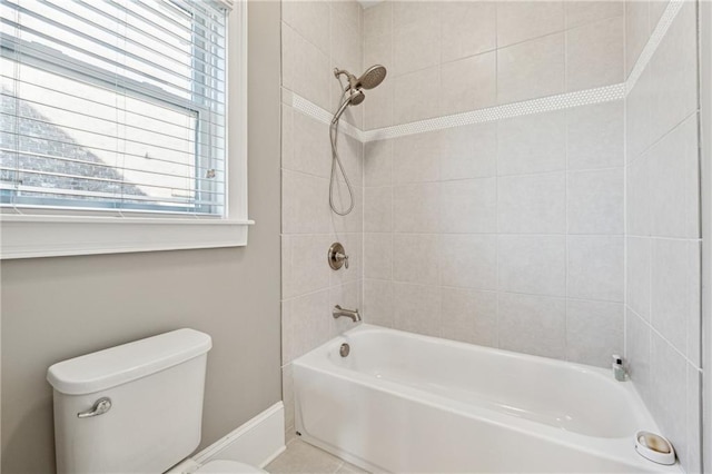 bathroom featuring toilet and tiled shower / bath