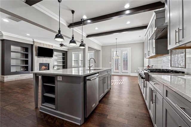 kitchen featuring pendant lighting, a center island with sink, sink, gray cabinets, and stainless steel appliances