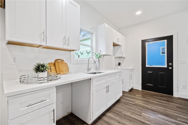 kitchen with a sink, dark wood-style floors, light countertops, and white cabinetry