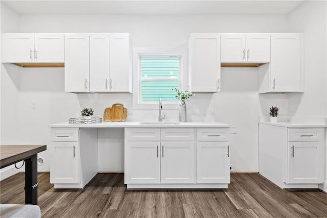 kitchen with dark wood-style floors, white cabinetry, and a sink