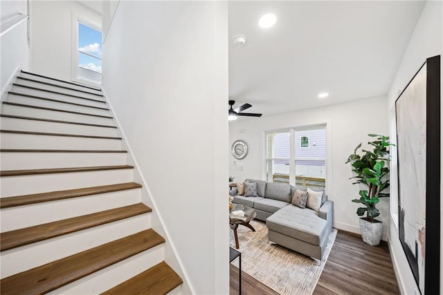 stairway with a ceiling fan, plenty of natural light, wood finished floors, and recessed lighting