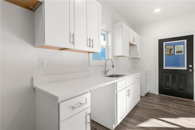 kitchen with a sink, white cabinetry, recessed lighting, light countertops, and dark wood-style flooring