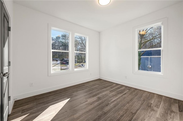 spare room with dark wood-style floors and baseboards