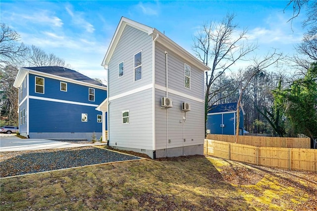 view of side of property with crawl space, an AC wall unit, and fence