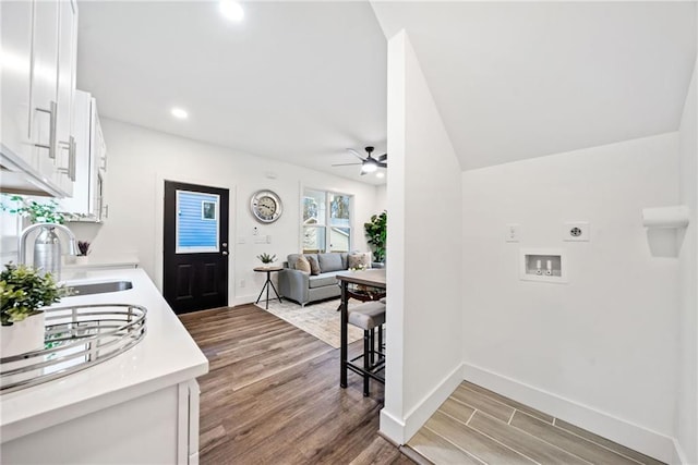 laundry room featuring laundry area, hookup for an electric dryer, light wood finished floors, and a sink