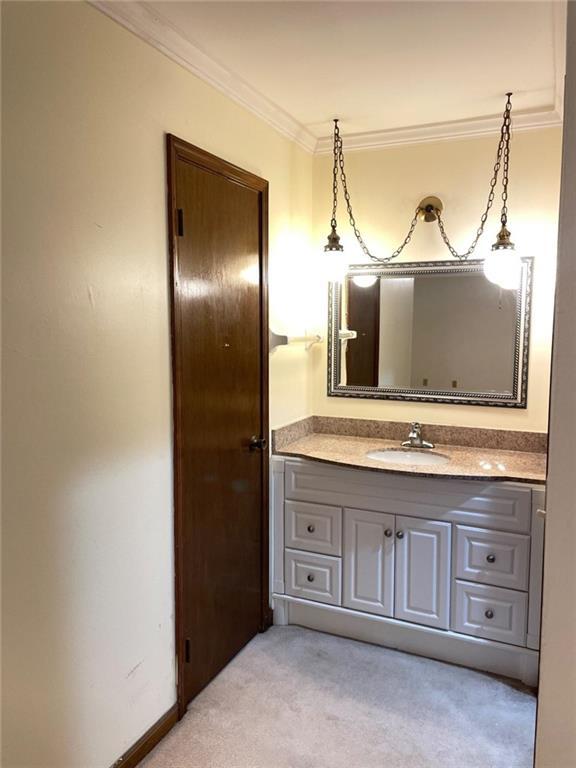 bathroom with ornamental molding and vanity