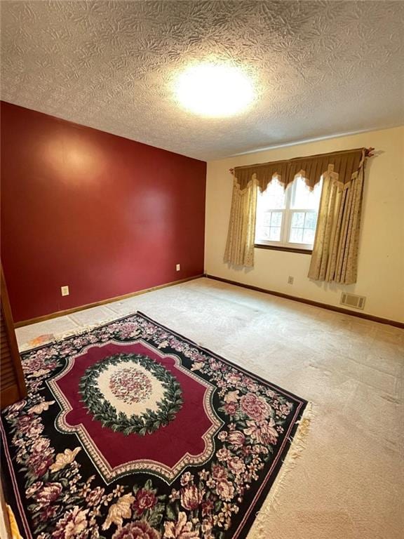 empty room featuring carpet floors and a textured ceiling