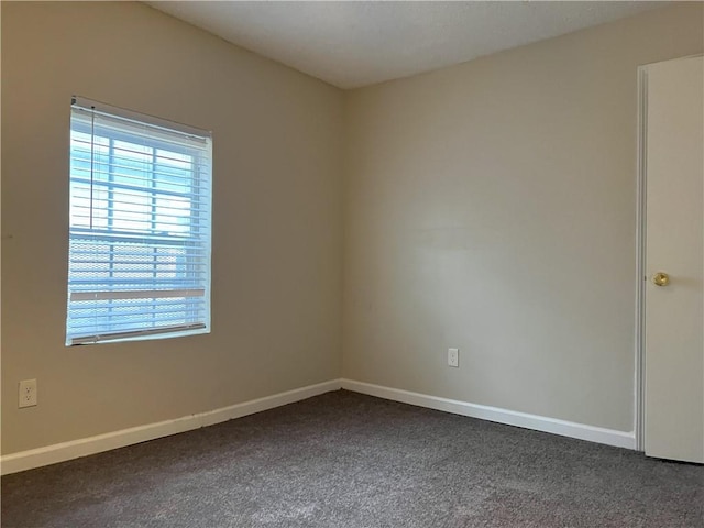 spare room featuring dark carpet