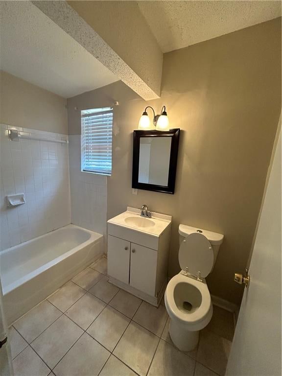 full bathroom featuring tiled shower / bath, a textured ceiling, toilet, vanity, and tile patterned floors