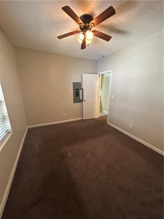 unfurnished bedroom featuring electric panel, dark colored carpet, a textured ceiling, and ceiling fan