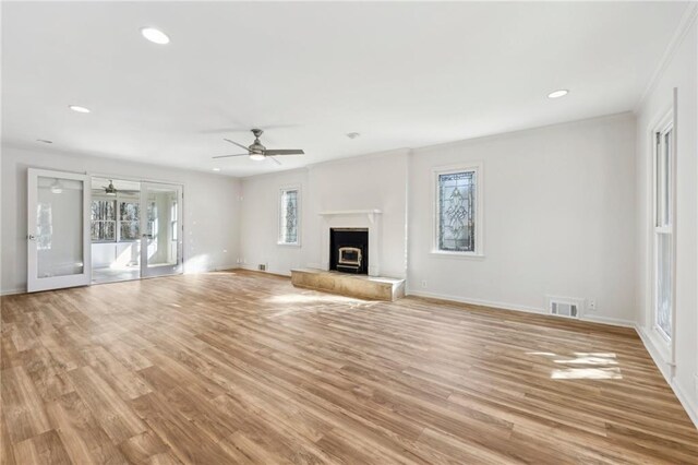 unfurnished living room with crown molding, ceiling fan, and light hardwood / wood-style flooring