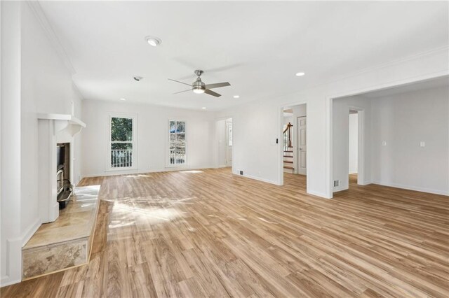 unfurnished living room featuring ceiling fan and light wood-type flooring