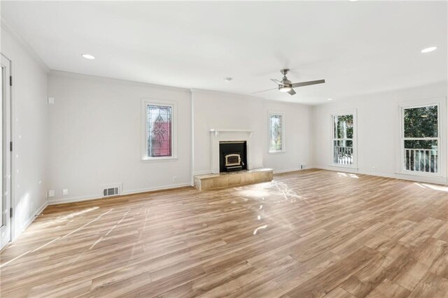 unfurnished living room with ornamental molding, ceiling fan, and light wood-type flooring