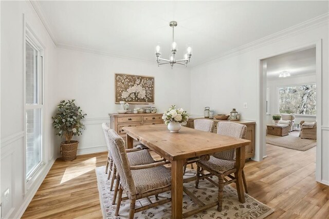 unfurnished dining area with light hardwood / wood-style floors, an inviting chandelier, a healthy amount of sunlight, and crown molding