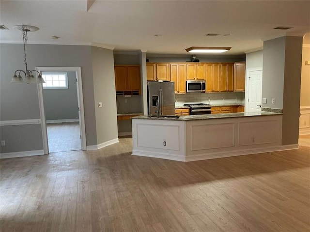 kitchen with pendant lighting, appliances with stainless steel finishes, kitchen peninsula, and crown molding