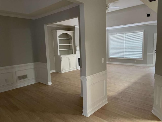 hallway with light hardwood / wood-style floors and ornamental molding