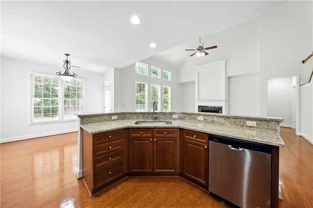 12554 Huntington Trce, Alpharetta, GA 30005 - kitchen with stainless steel dishwasher, a sink, wood finished floors, a ceiling fan, and a fireplace