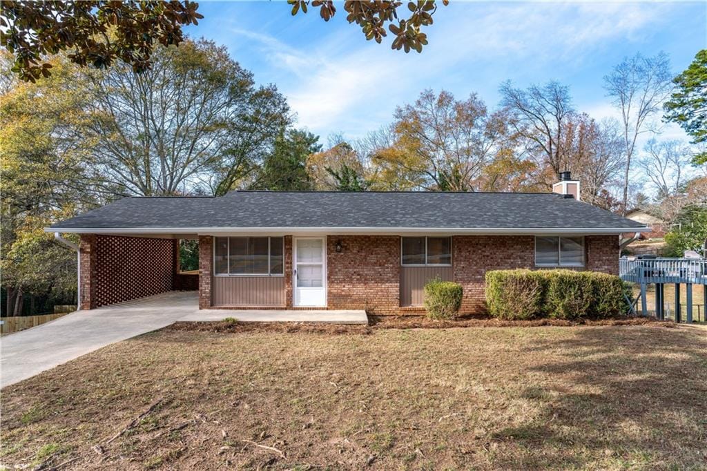 ranch-style home featuring a carport and a front yard