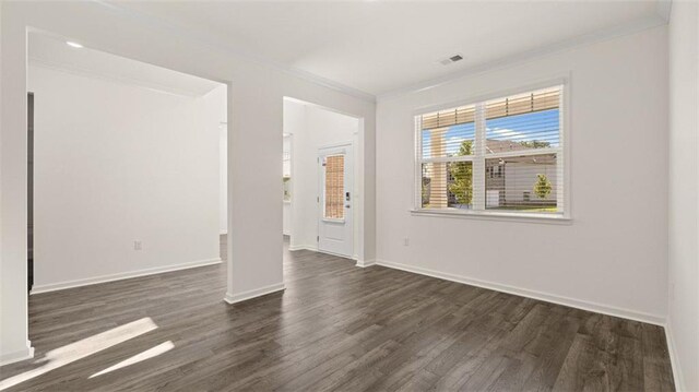 1149 Blue Juniper Cir, Loganville, GA 30052 - spare room with crown molding, dark wood-style flooring, and baseboards