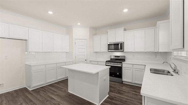 1149 Blue Juniper Cir, Loganville, GA 30052 - kitchen with appliances with stainless steel finishes, a sink, tasteful backsplash, a center island, and white cabinetry